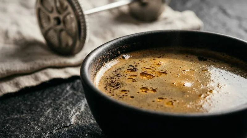 Mörkt presskaffe med tunna oljeskikt på ytan från metallfilter